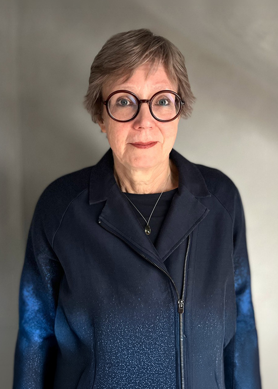 Portrait photo of Hilke Schaer, Car2Car Project Manager at BMW Group. She wears a dark blue jacket and distinctive round glasses with a red frame, looking friendly into the camera.