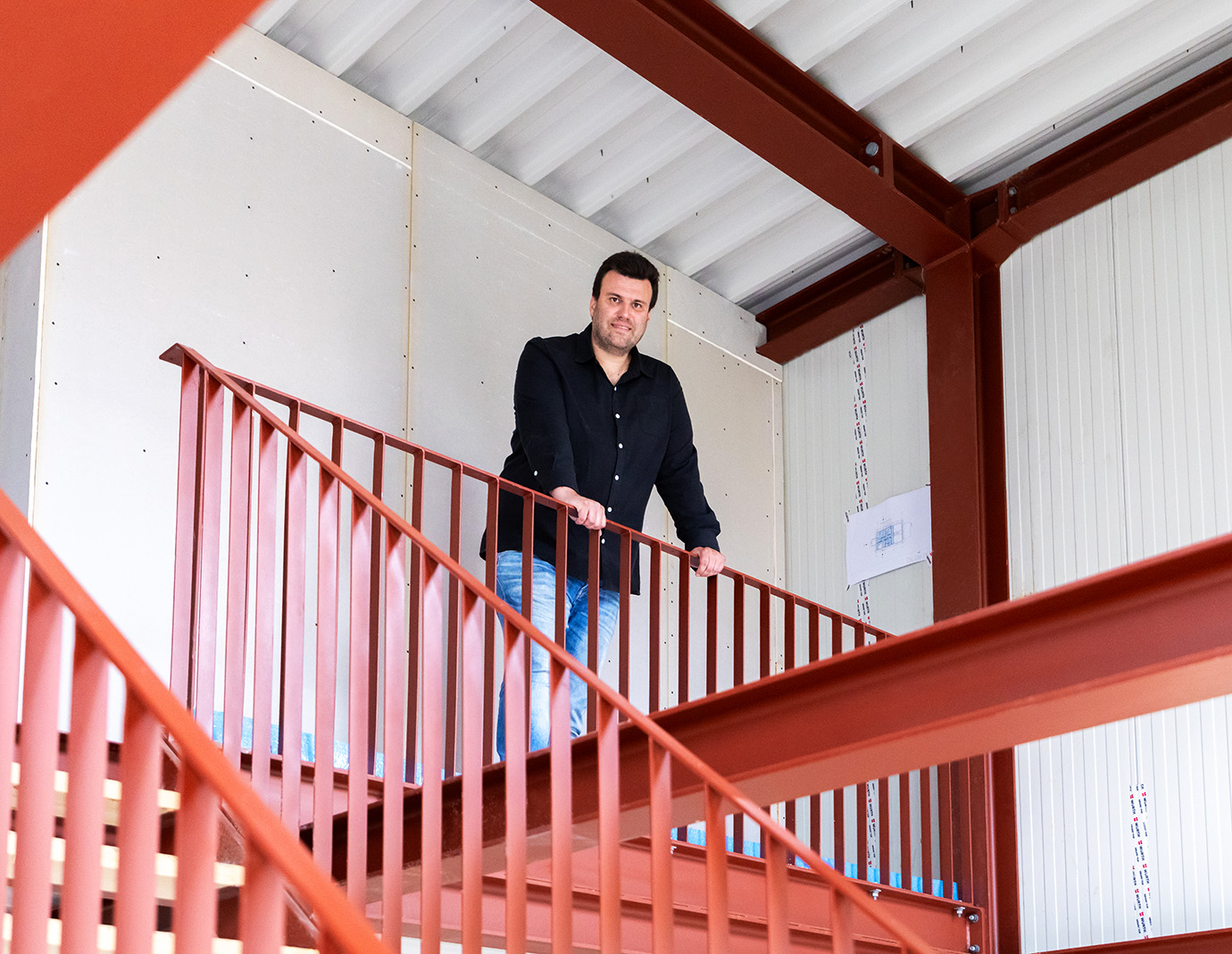 Christoph Jenner steht auf der Galerie im Rohbau seines Green Steel Home.