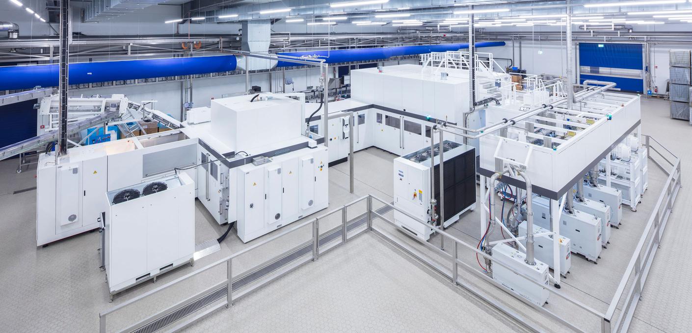 Industrielle Blockmaschine in einer hellen Produktionshalle, die Streckblasen von PET-Flaschen und deren Innenbeschichtung in einer integrierten Anlage verbindet.