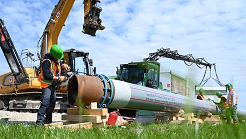 Arbeiter schleift H2ready-Rohr von Mannesmann für den Transport von Gas und grünem Wasserstoff. Arbeiter schleift H2ready-Rohr von Mannesmann für den Transport von Gas und grünem Wasserstoff