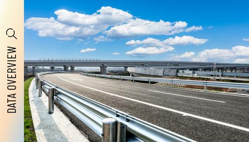Multi-lane highway intersection with bridges and overpasses under a cloudy sky.