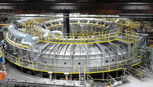 Rotary hearth furnace at the Zeithain plant A large circular rotary hearth furnace inside the Mannesmannröhren-Werk Zeithain plant, surrounded by yellow walkways and pipework.