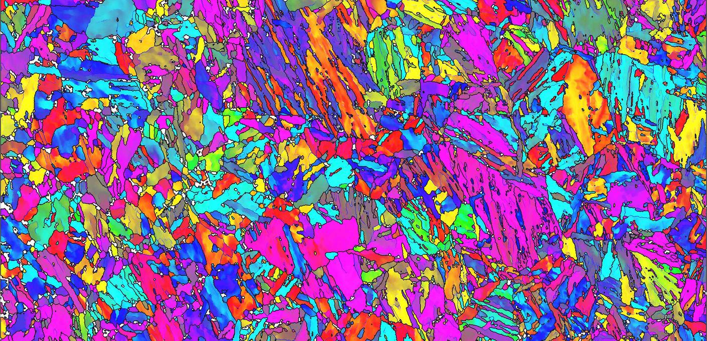 Color-coded microscopic image of steel microstructure in intense pink, purple, green, yellow and blue tones showing the complex microstructure of different steel phases. Color-coded microscopic image of steel microstructure in intense pink, purple, green, yellow and blue tones showing the complex microstructure of different steel phases.