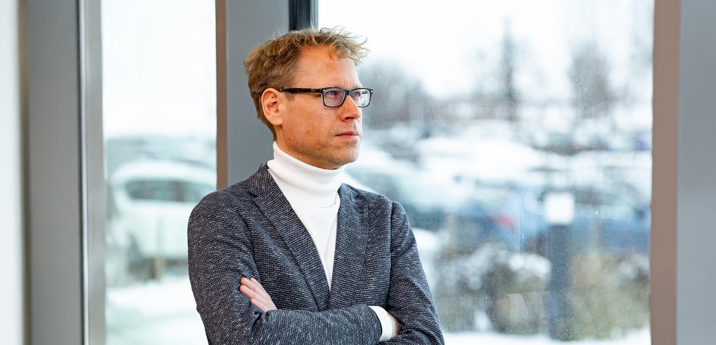 Friedrich Ellebrecht stands with his arms crossed, wearing a suit and a white turtleneck sweater, in front of a window. Friedrich Ellebrecht stands with his arms crossed, wearing a suit and a white turtleneck sweater, in front of a window.