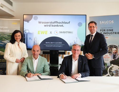 Four people sit at a table during the ceremonial signing of the hydrogen supply contract. In the background, banners with the logos of EWE and SALCOS® and the inscription "Wasserstoffhochlauf wird konkret" are visible. From left to right: Gitta Connemann (Parliamentary State Secretary at the BMWE), Stefan Dohler (CEO EWE AG), Gunnar Groebler (CEO Salzgitter AG) and Lower Saxony's Minister President Olaf Lies.