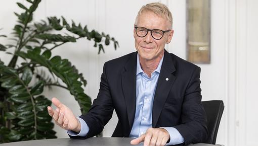 Porträtfoto von Benedikt Ritterbach, Geschäftsführer der Salzgitter Mannesmann Forschung GmbH (SZMF). Er trägt eine Brille, ein weißes Hemd und ein dunkles Sakko und blickt freundlich in die Kamera. Im Hintergrund sind Pflanzen und ein helles Interieur zu erkennen.