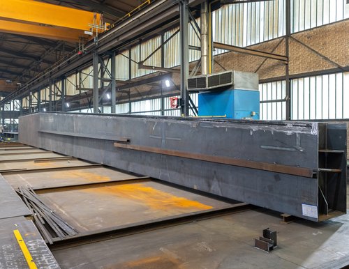 Stahlbauteil in einer Halle, das für die Montage vorbereitet wird. Stahlbauteil in einer Halle, das für die Montage vorbereitet wird.