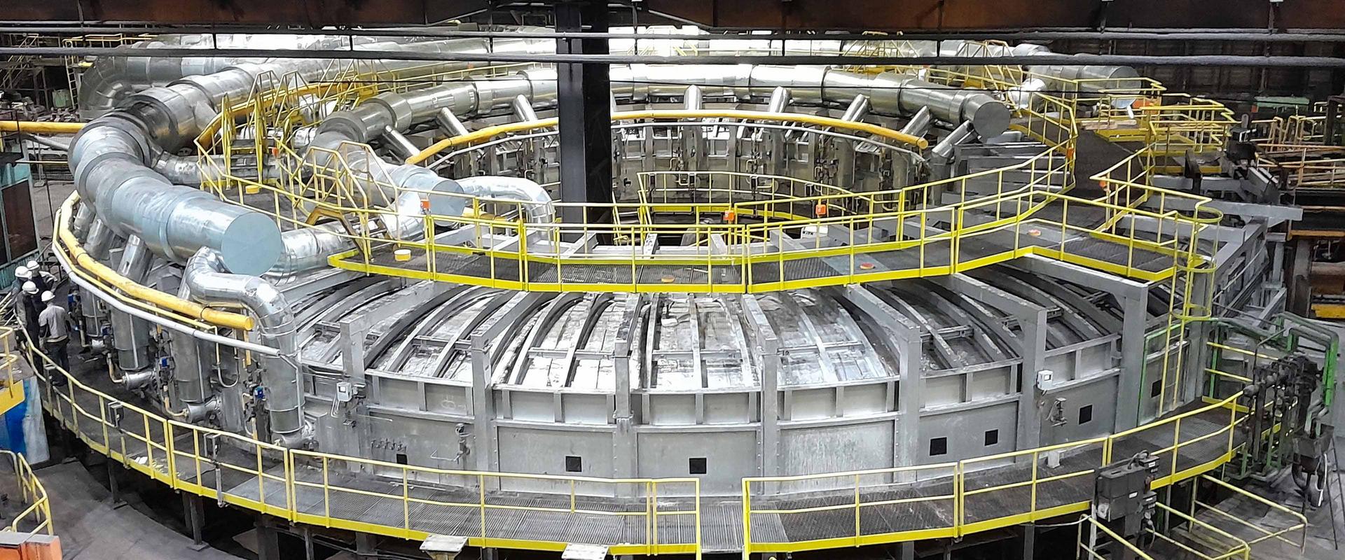 Rotary hearth furnace at the Zeithain plant A large circular rotary hearth furnace inside the Mannesmannröhren-Werk Zeithain plant, surrounded by yellow walkways and pipework.