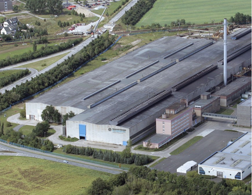 Der Standort Zeithain aus der Luft. Das Foto bildet den Produktionsstandort der Mannesmannröhren-Werk GmbH in Zeithain ab. Auf dem Foto sind die Gebäude und umgebene grüne Wiesen zu sehen.