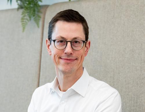 [Translate to Englisch:] Matthias Schneider, Salzgitter Mannesmann Forschung GmbH, vor heller Wand mit Pflanzendekoration, trägt ein weißes Hemd und BrilleMatthias Schneider, Salzgitter Mannesmann Forschung GmbH, in front of a light wall with plant decoration, wearing a white shirt and glasses.