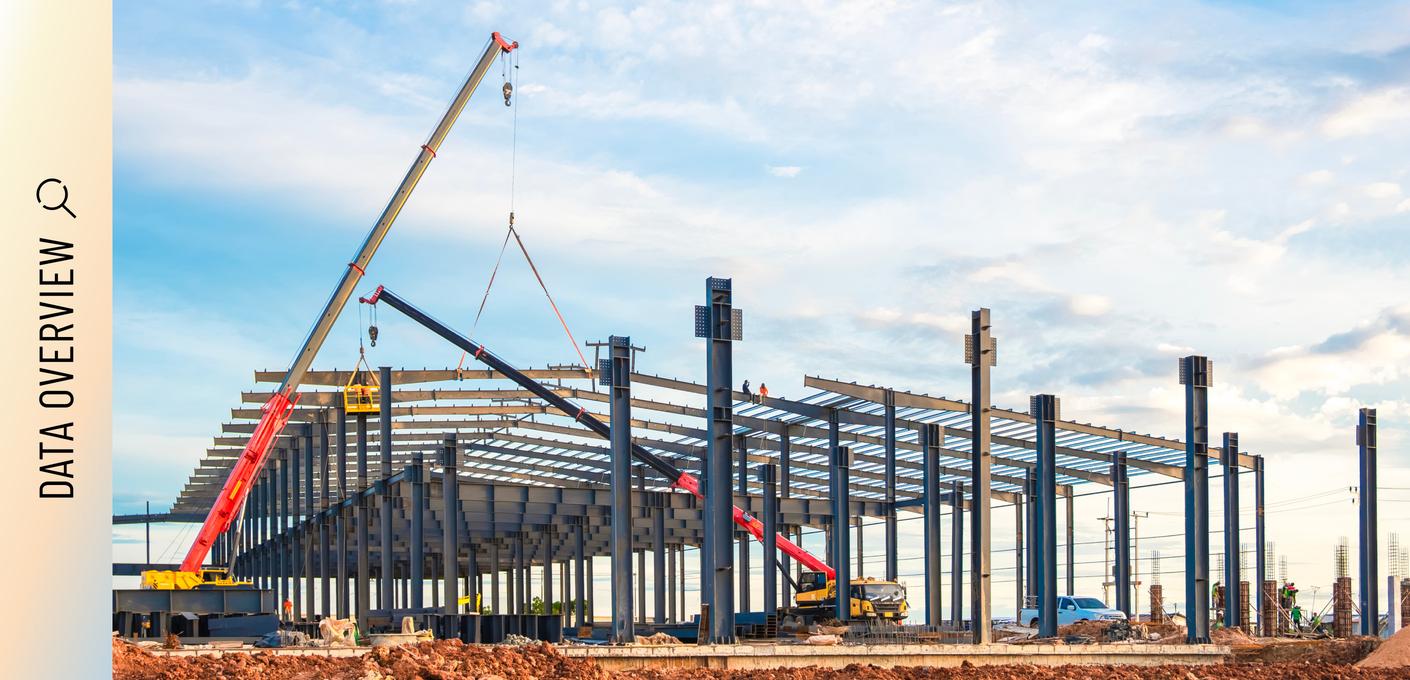 Construction site with crane and steel structure of an industrial building.