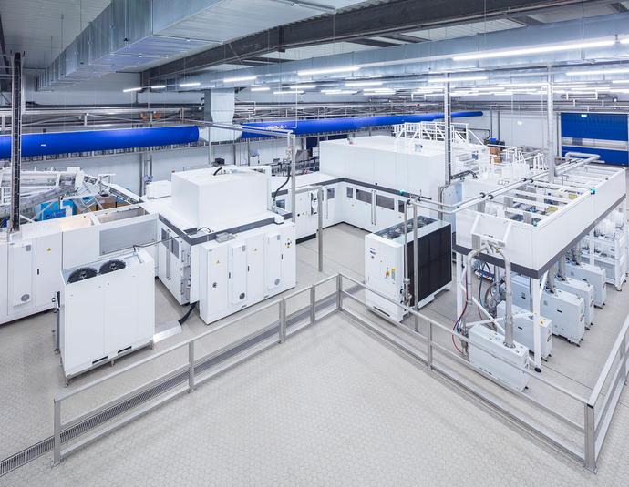 Industrielle Blockmaschine in einer hellen Produktionshalle, die Streckblasen von PET-Flaschen und deren Innenbeschichtung in einer integrierten Anlage verbindet.